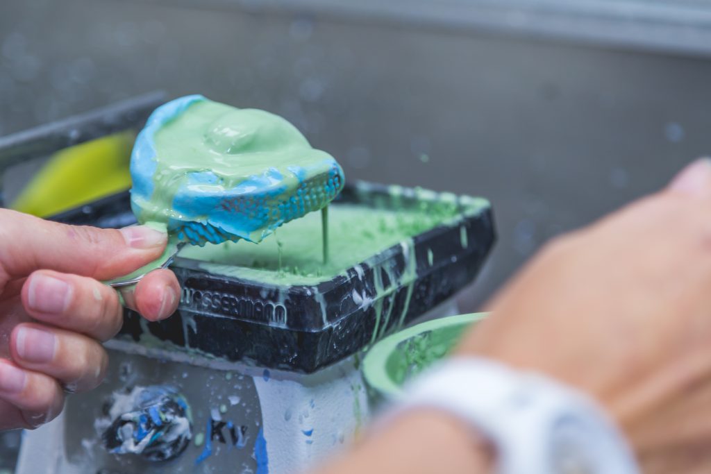 Tandprothese wordt schoongemaakt onder stromend water in de wasbak met zeep