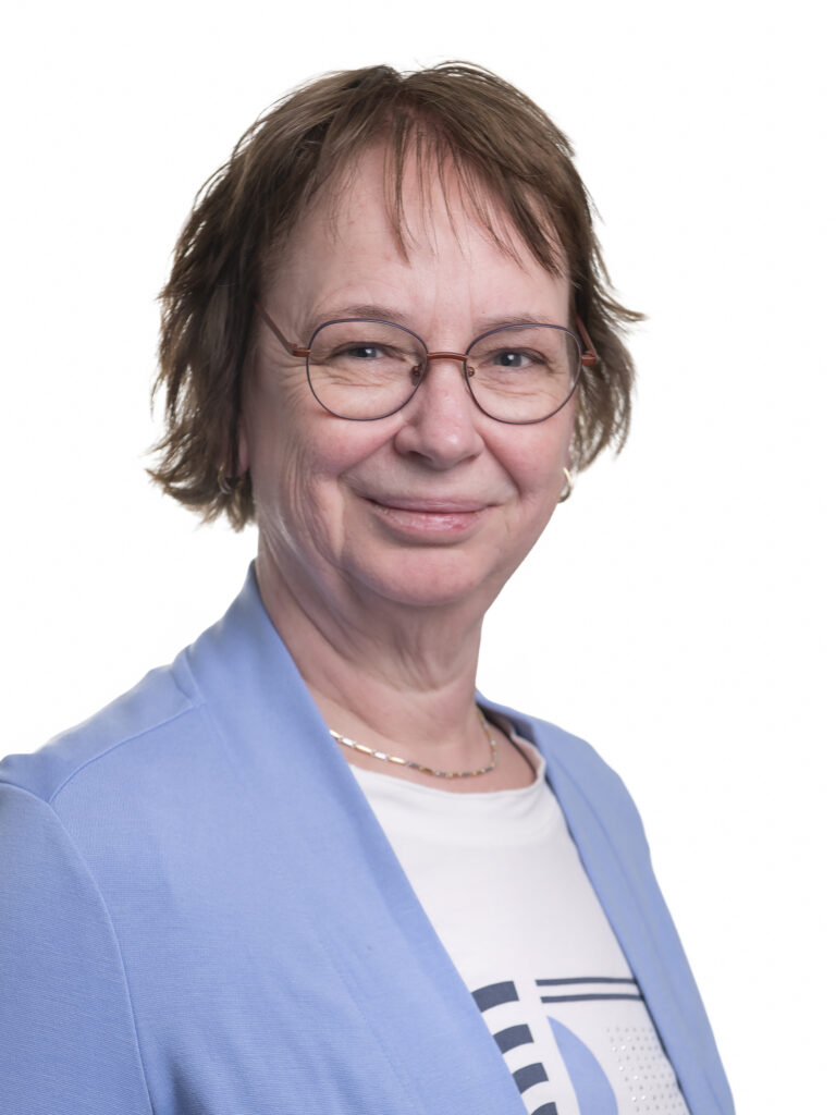 Professionele tandprotheticus in blauwe blazer met bril en vriendelijke glimlach