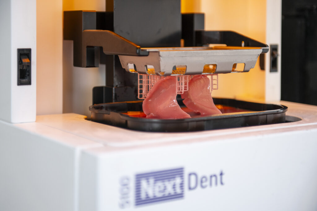 3D printer van NextDent print roze gebitsprothese voor tandprothetische behandeling